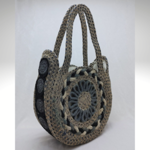 Handcrafted circular jute mini handbag featuring a layered sunburst woven pattern, natural fiber texture, and a structured round silhouette with matching jute handles.