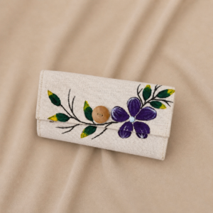 Handcrafted natural fiber fold wallet featuring a hand-painted purple flower, green leaf branch details, wooden button accent, and compact rectangular pouch shape.