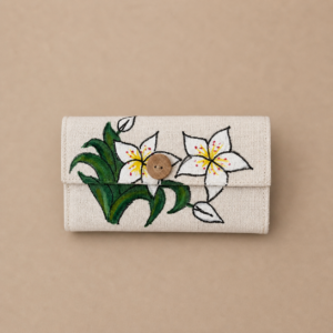 Handcrafted natural fiber fold wallet featuring hand-painted white lily flowers, green leaves, wooden button detail, snap closure, and multiple inner compartments for cards and small essentials.