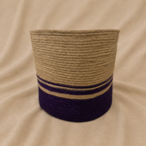 Handcrafted natural jute cylindrical planter basket with earthy woven texture, deep purple accent band at the base, and protective inner liner for decorative plant styling or small storage.